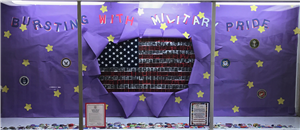 Purple paper with an American flag bursting out of the middle.  The white stripes are made up of student pictures