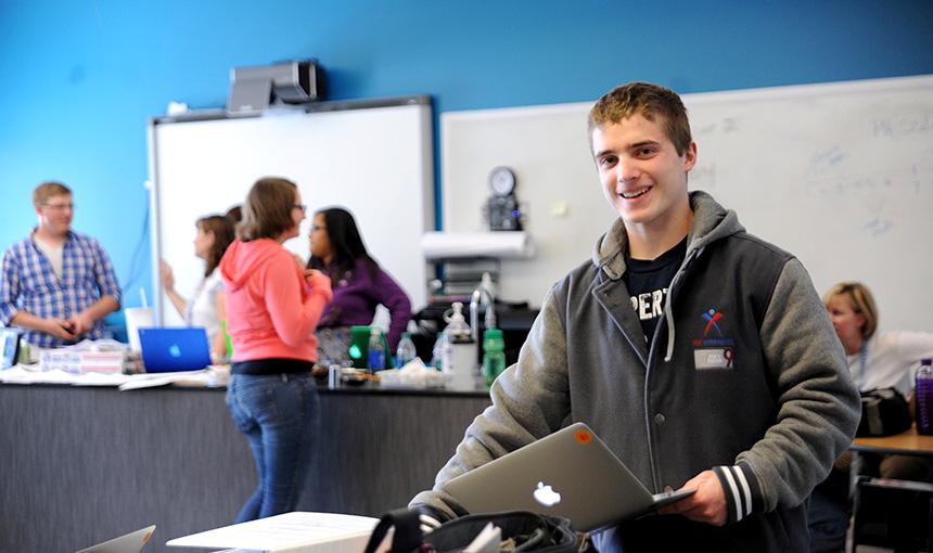  Jay Barnish, a senior at Falcon Virtual Academy, grabs a computer April 21.
